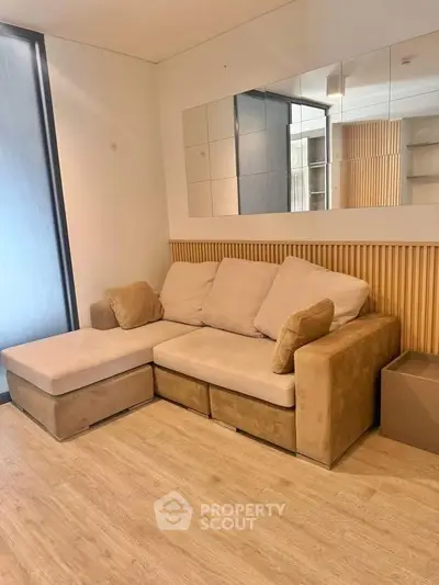 Modern living room with stylish beige sectional sofa and wooden accents