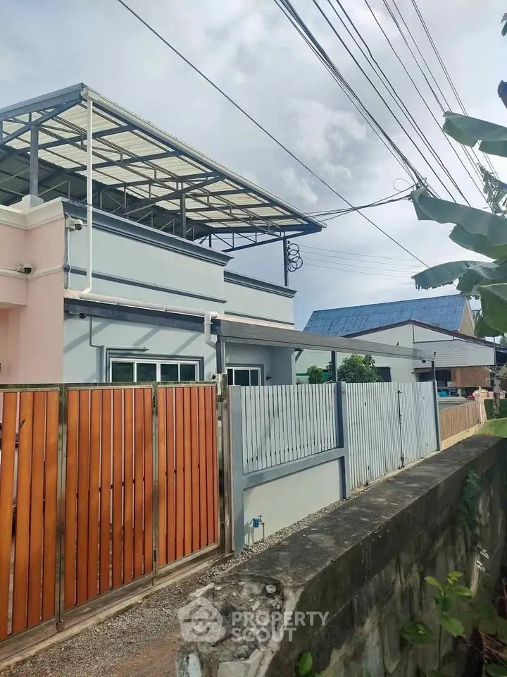 Charming suburban home with modern rooftop and wooden fence, perfect for family living.