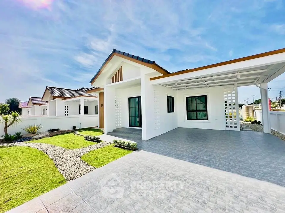 Charming modern bungalow with spacious driveway and lush green lawn under a clear blue sky.