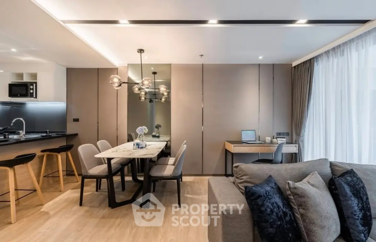 Modern open-plan living room with stylish dining area and sleek kitchen design.