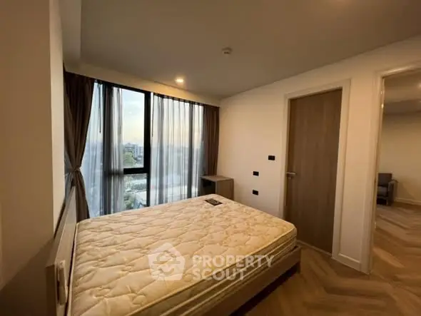 Cozy bedroom with large window and modern decor in a stylish apartment