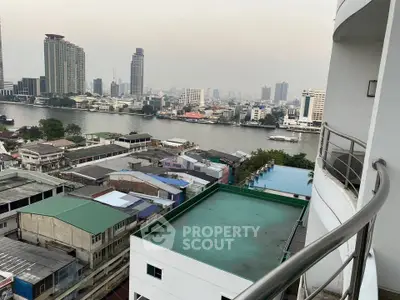 Stunning river view from high-rise balcony overlooking city skyline and waterfront buildings.