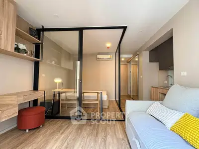 Modern living room with glass partition, wooden flooring, and stylish furniture in a contemporary apartment.