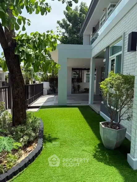 Charming modern home with lush green garden and spacious outdoor area, perfect for relaxation and entertaining.