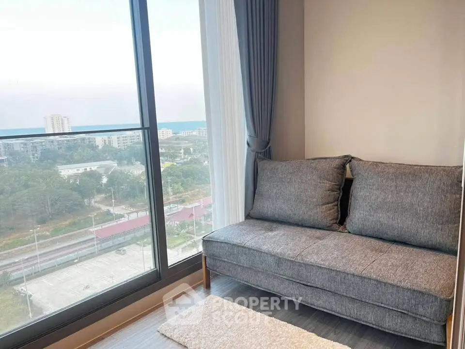 Modern living room with large window offering stunning city view