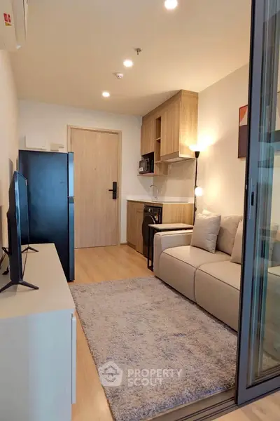 Modern living room with cozy sofa and compact kitchen in stylish apartment