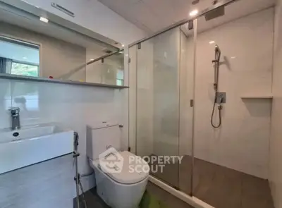 Modern bathroom with glass shower and sleek fixtures in a contemporary home.