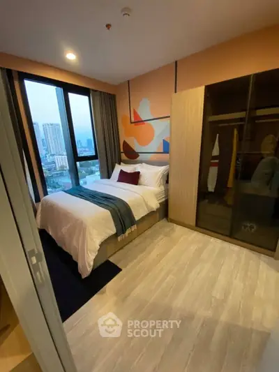 Modern bedroom with city view, featuring stylish decor and ample natural light.