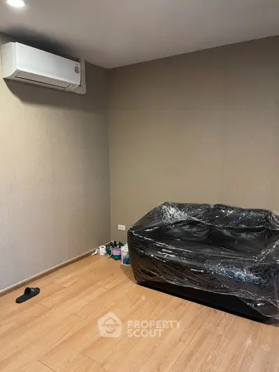 Modern unfurnished room with air conditioning and wooden flooring, ideal for customization.