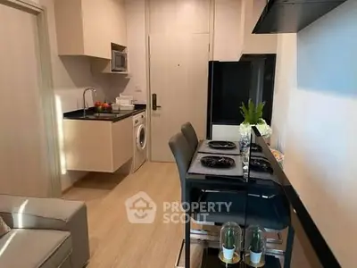 Modern kitchen with dining area and washing machine in compact apartment