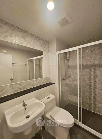 Modern bathroom with glass shower and stylish tile design.