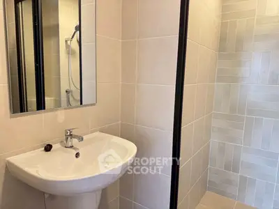 Modern bathroom with sleek sink and tiled shower area