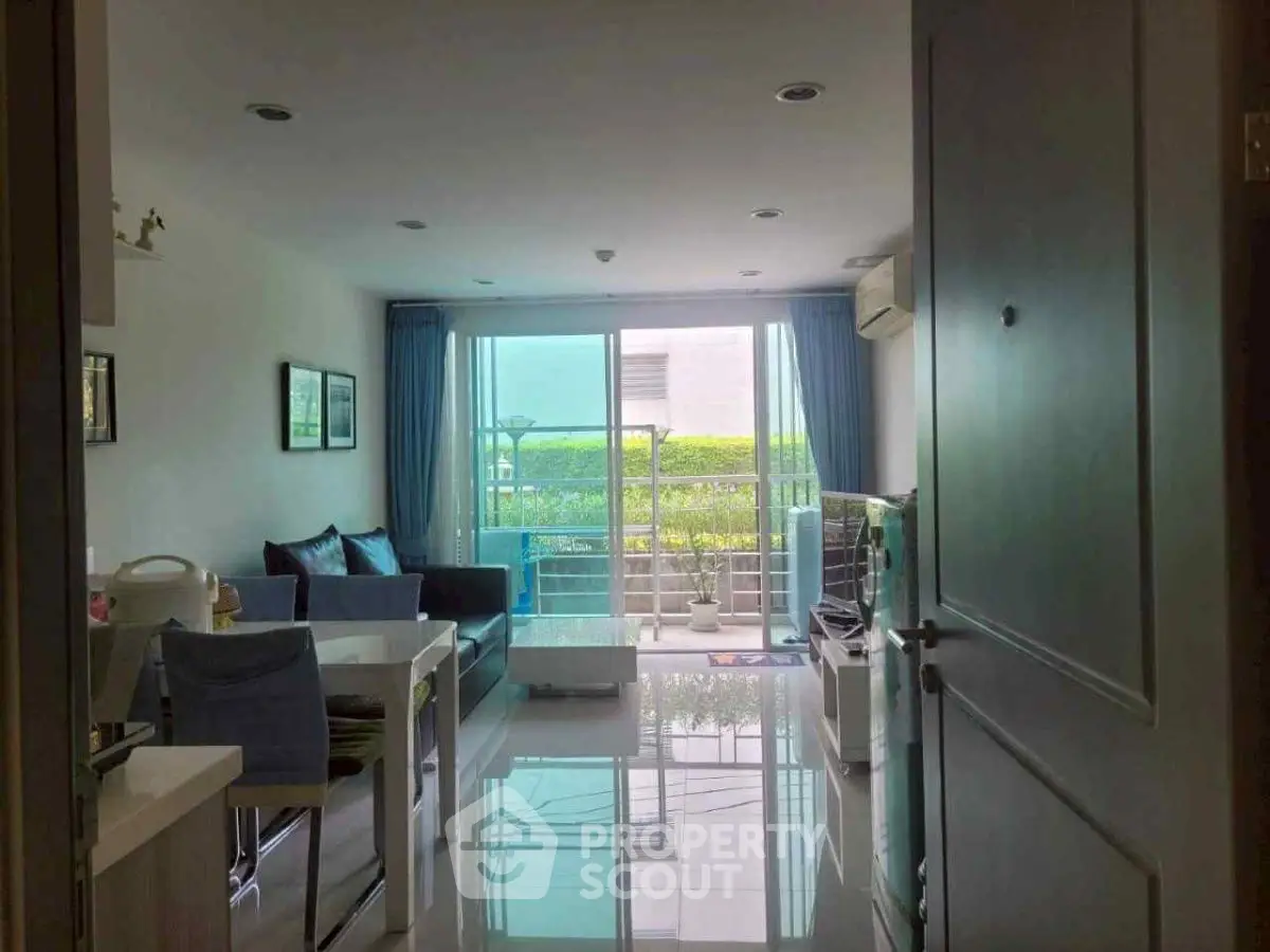 Modern living room with sleek design and balcony view, featuring stylish furniture and natural light.