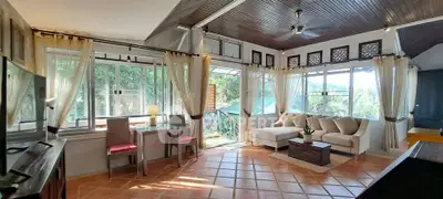 Spacious living room with large windows and scenic view, featuring elegant decor and ample natural light.