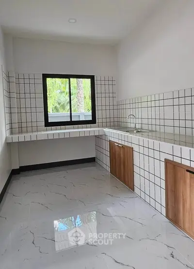 Modern kitchen with sleek white tiles and large window