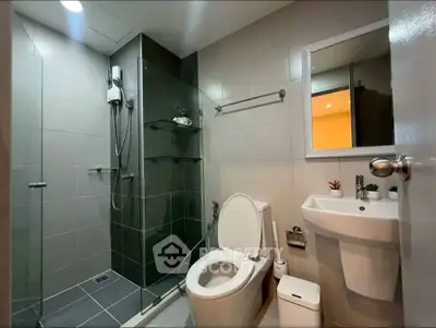 Modern bathroom with glass shower and sleek fixtures in contemporary apartment.