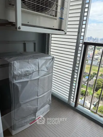 High-rise balcony with washing machine and city view, perfect for urban living convenience.