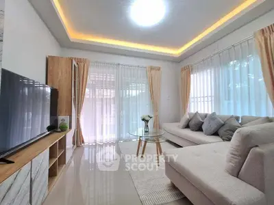 Modern living room with elegant decor and large windows for natural light.