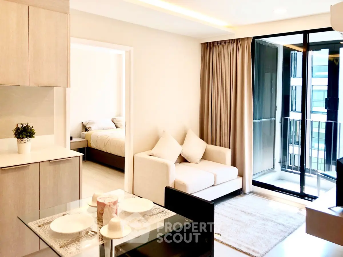 Modern open-plan living room with cozy sofa, dining area, and balcony access in a stylish apartment.