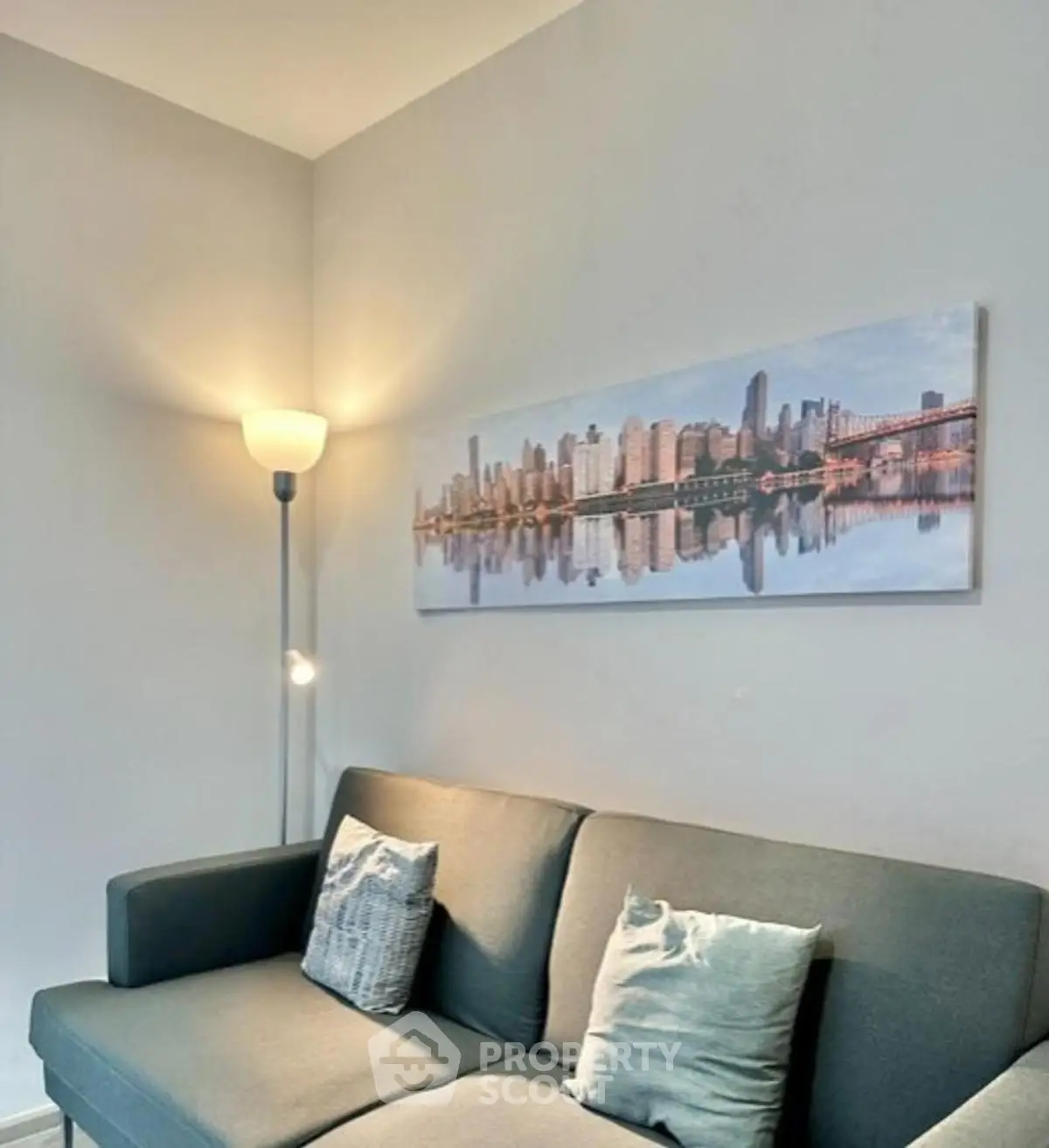 Modern living room with stylish sofa and cityscape artwork, perfect for urban living.