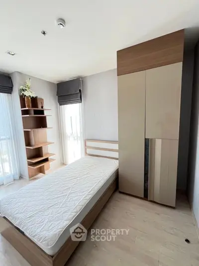 Modern bedroom with minimalist design, featuring a sleek wardrobe and natural light.