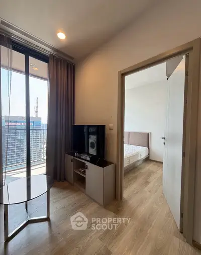 Modern apartment interior with city view, featuring a cozy living area and bedroom.