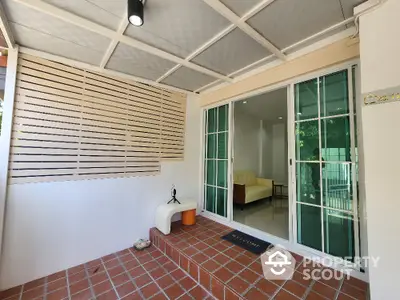 Charming entrance with sliding glass doors and cozy seating area