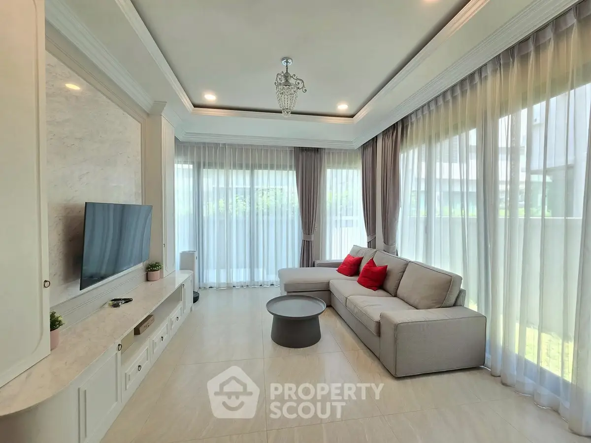 Elegant living room with modern decor, large windows, and cozy seating area.