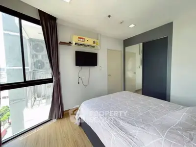 Bright bedroom with large window and modern decor in a stylish apartment.