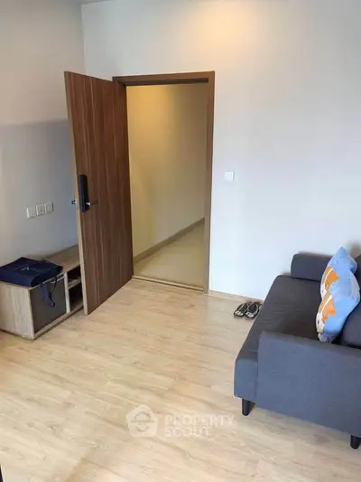 Modern living room with wooden flooring and stylish gray sofa, perfect for cozy living.