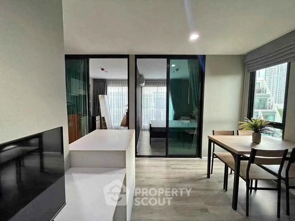 Modern living room with dining area and large windows in a stylish apartment.