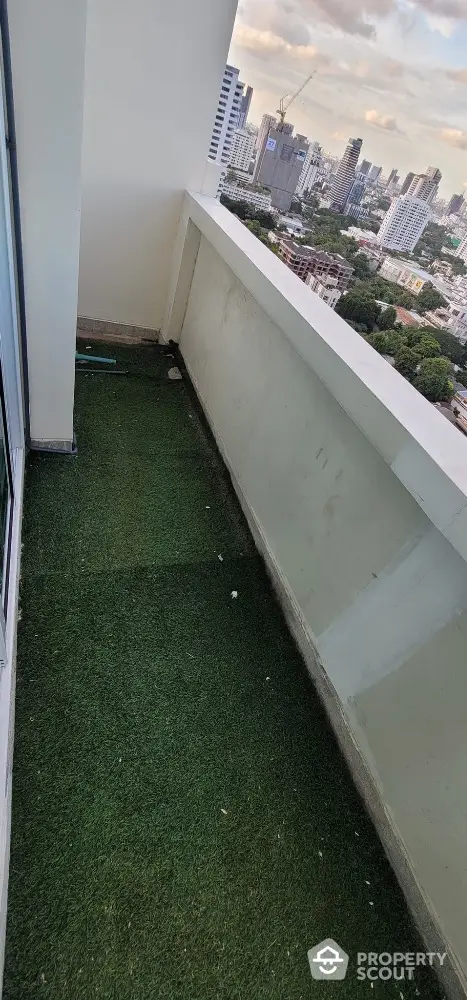 Spacious balcony with artificial grass and stunning city view