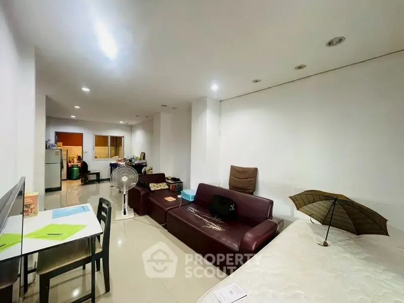 Spacious living area with modern furniture and bright lighting, ideal for comfortable living.