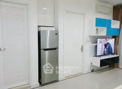 Modern living room with sleek fridge and wall-mounted TV, showcasing minimalist design and efficient use of space.