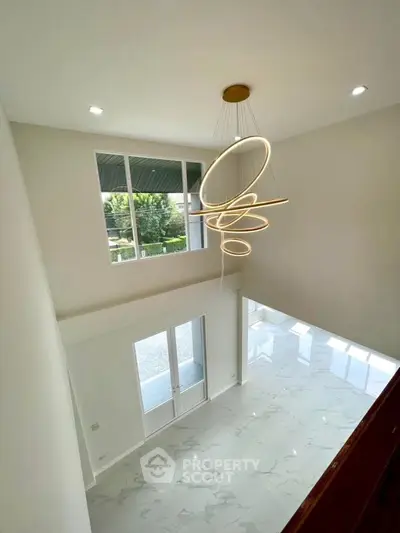 Spacious modern living room with high ceiling and elegant chandelier