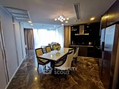 Luxurious open-layout kitchen and dining area with marble flooring and modern lighting.