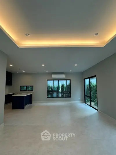 Spacious modern living room with large windows and elegant lighting