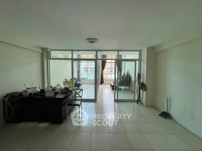 Spacious living room with glass doors leading to a bright balcony, ideal for modern living.