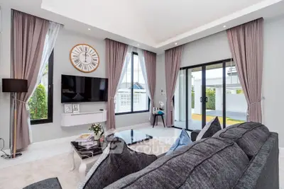Luxurious modern living room with elegant decor and large windows opening to a garden view.