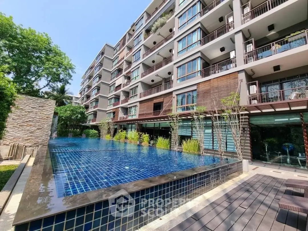 Modern apartment building with a luxurious outdoor pool and lush greenery.
