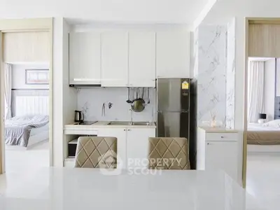 Modern kitchen with sleek design and adjacent bedrooms in a stylish apartment.