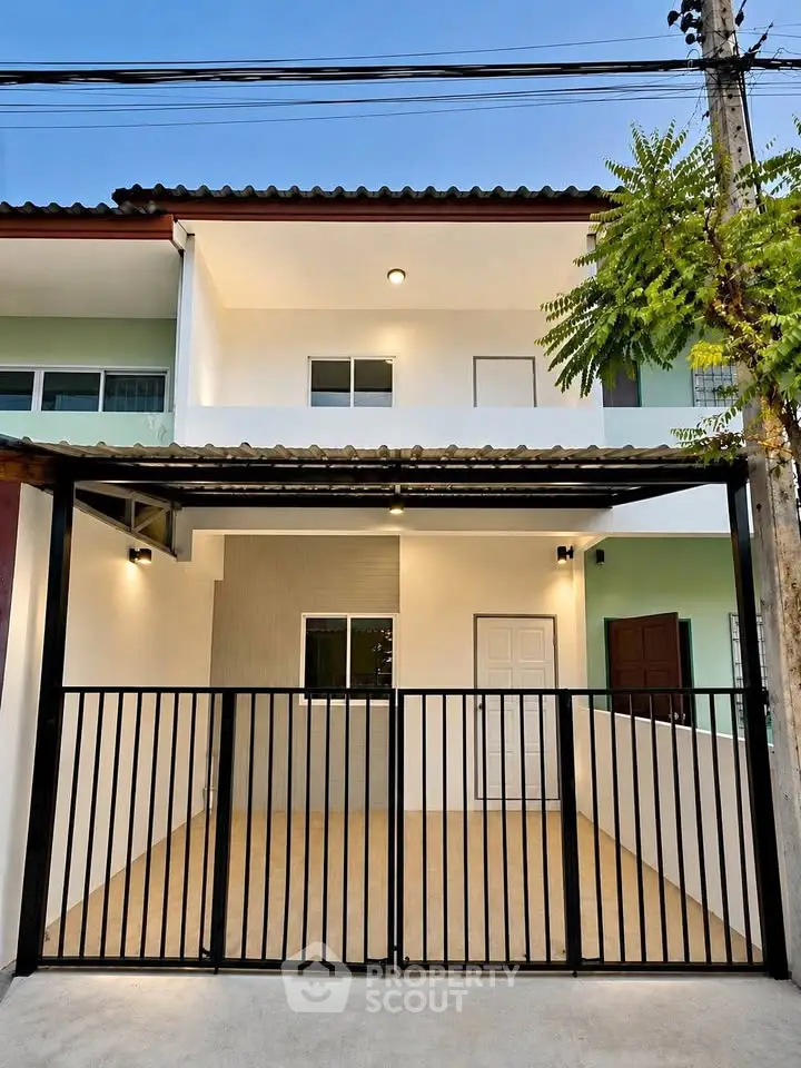 Modern two-story townhouse with gated entrance and contemporary design.