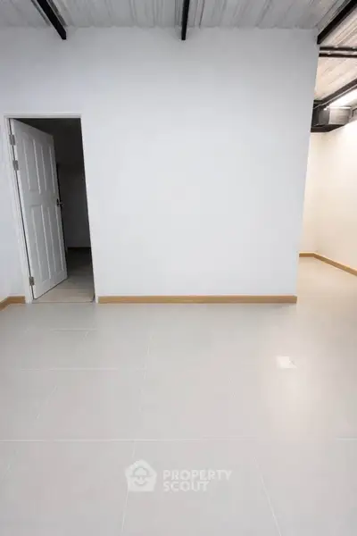 Spacious empty room with white walls and tiled floor, ready for customization.