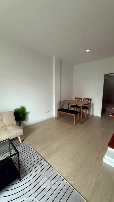 Spacious living room with modern furniture and wooden flooring in a bright apartment.