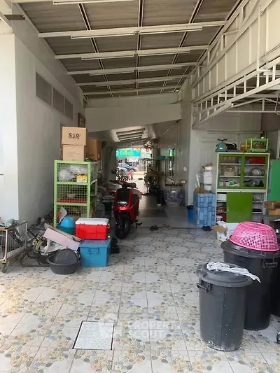 Spacious garage or storage area with tiled flooring and ample shelving, ideal for versatile use.