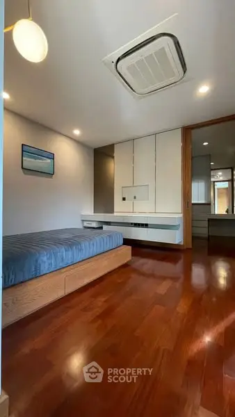 Modern bedroom with wooden flooring and built-in storage