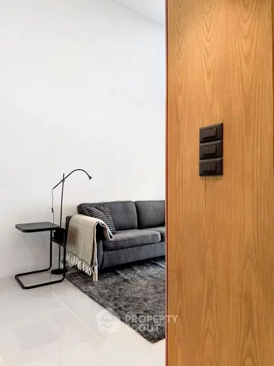 Modern living room with sleek sofa and stylish lamp, perfect for contemporary living.