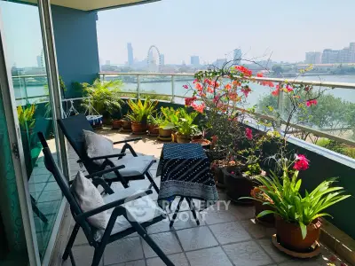 Spacious balcony with city skyline view and lush potted plants, perfect for relaxation.