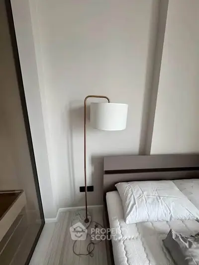 Modern bedroom with stylish floor lamp and cozy bed setup