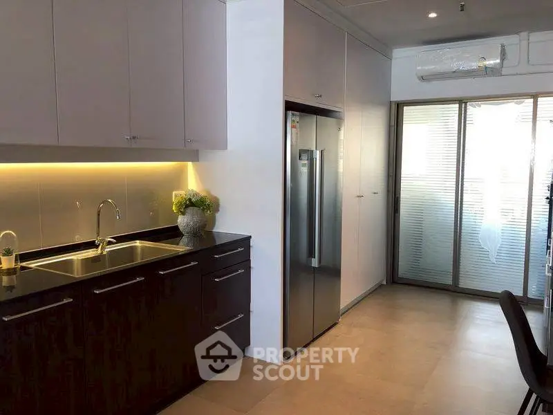 Modern kitchen with sleek cabinets and stainless steel fridge